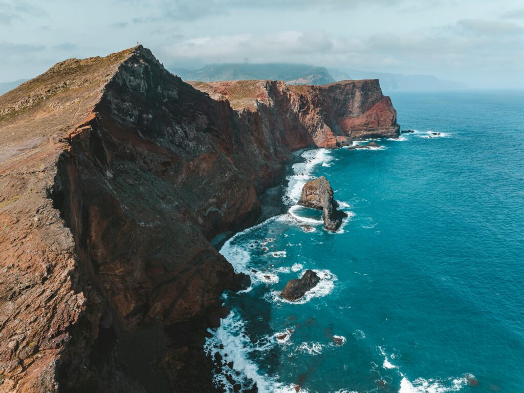 Stunning aerial drone view of Madeira’s cliffs and clear blue ocean, showcasing nature