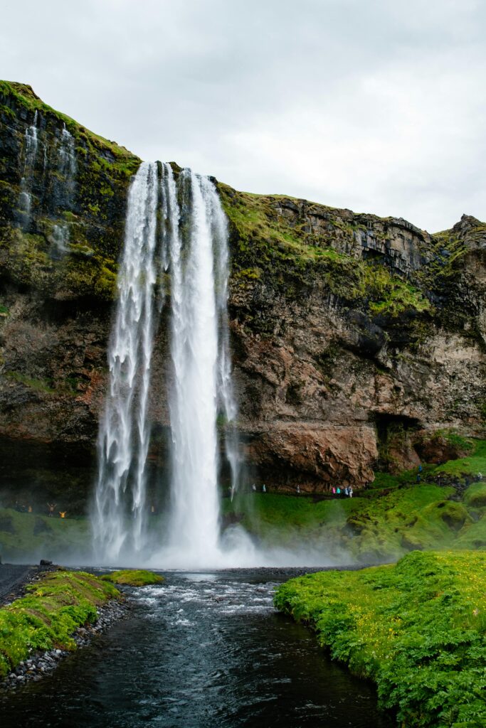 Majestic Seljalandsfoss waterfall cascading with lush green surroundings, perfect for travel enthusiasts.