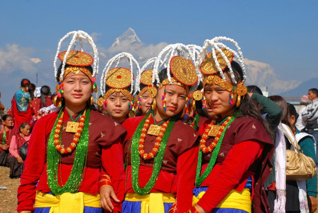 Group of Nepalese women in traditional attire at a vibrant outdoor cultural festival.