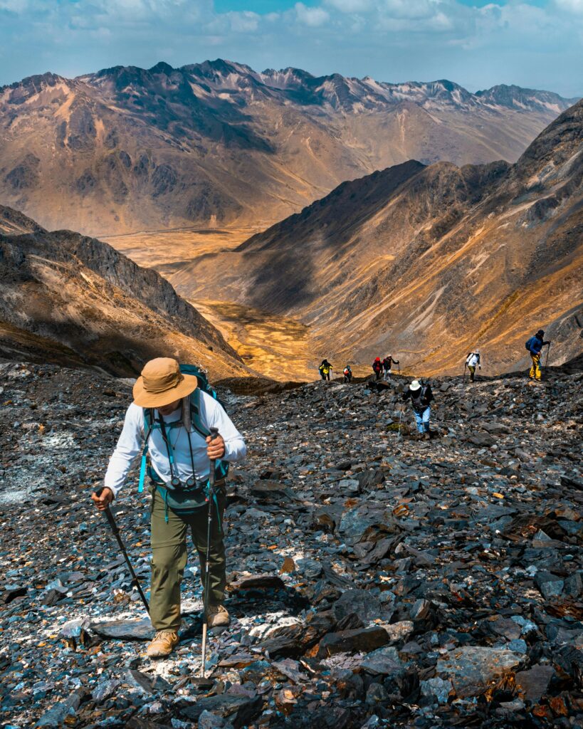 Hikers trekking the Andes mountains in Cuzco, Peru, under a clear sky.
