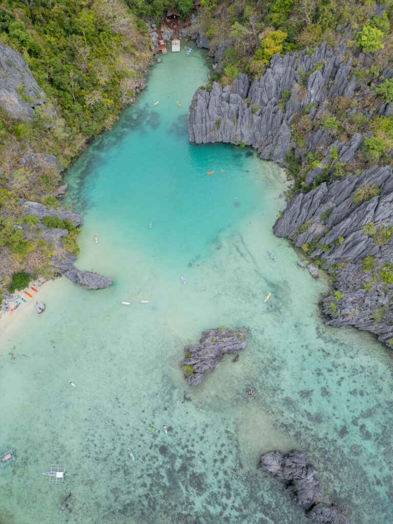 A stunning aerial capture of a turquoise lagoon surrounded by cliffs in the Philippines.