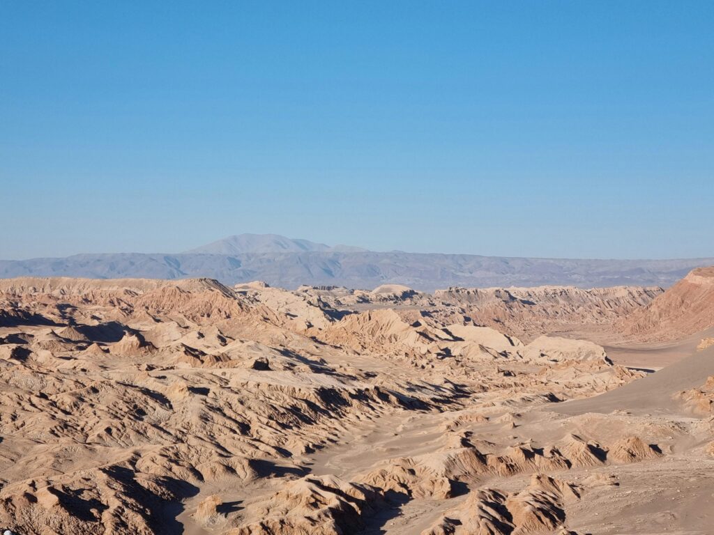 Scenic landscape of the Atacama Desert under a clear blue sky in San Pedro de Atacama, Chile.