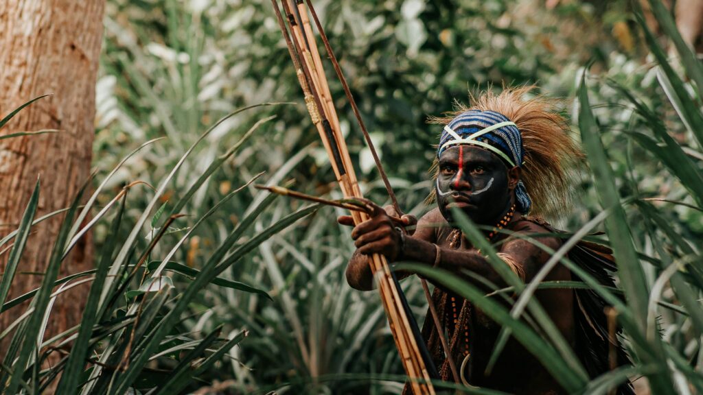 Tribal warrior with body paint and bow in Jayapura