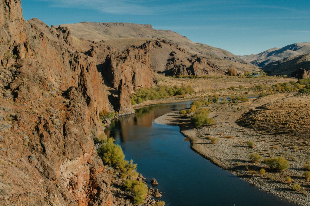 Stunning aerial view of a river winding through rocky mountains in Patagonia.