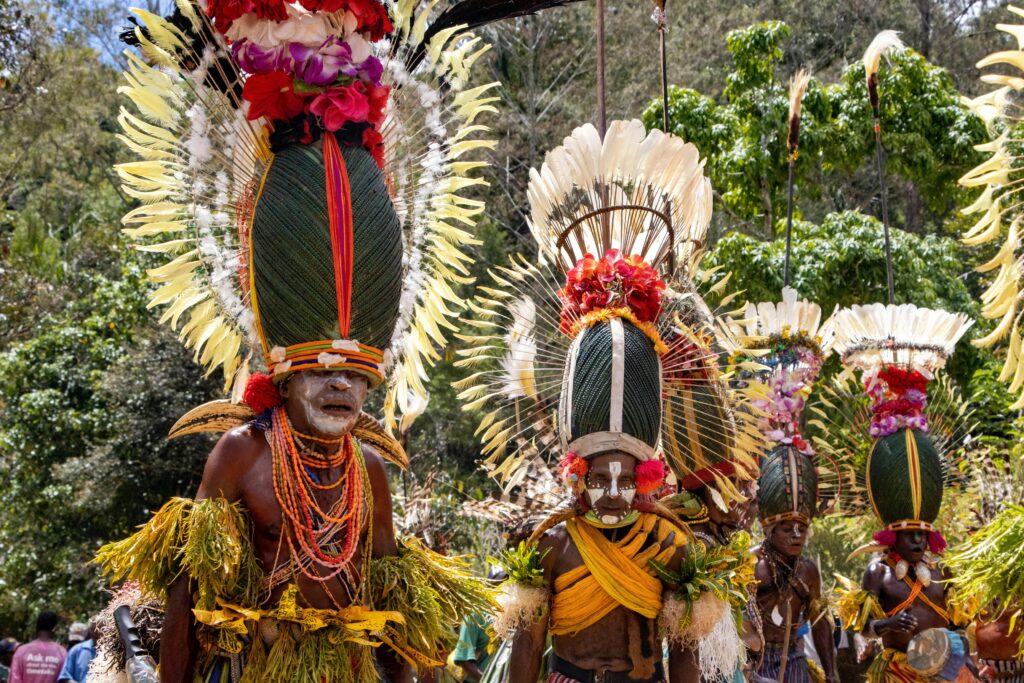 Colorful tribal dancers in traditional attire at a cultural festival in Papua New Guinea.