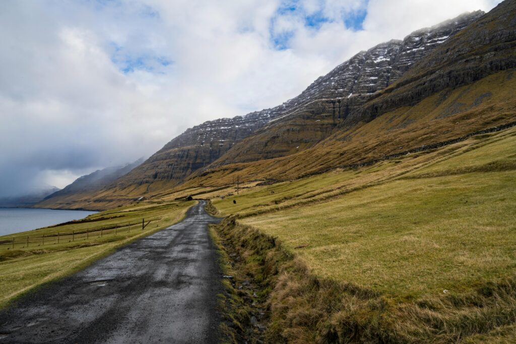 Explore the rugged landscapes of Faroe Islands with this stunning mountain road view.