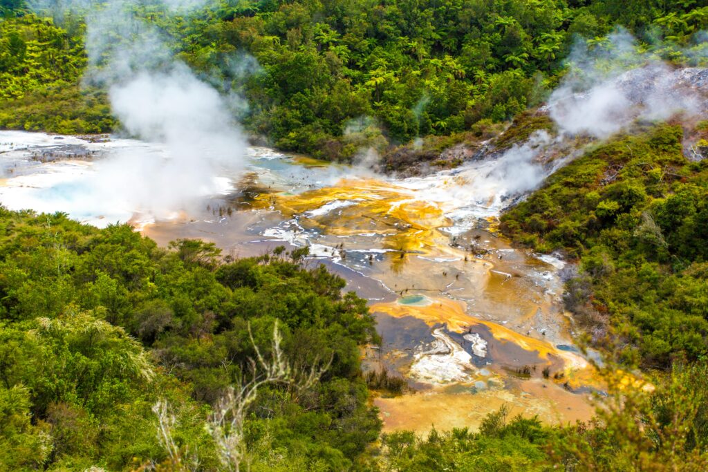 A stunning aerial shot of a colorful geothermal area surrounded by lush greenery in Taupo, New Zealand.