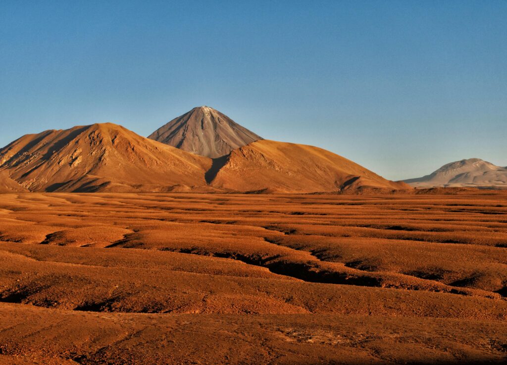Stunning landscape showcasing the Licancabur Volcano with arid terrain under a clear blue sky in the Atacama Desert.