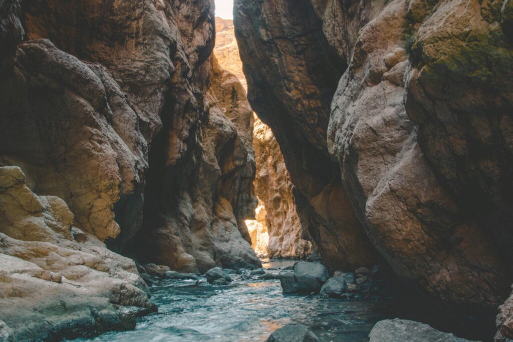 Stunning view of a mountain gorge with a flowing river and towering rocky cliffs.