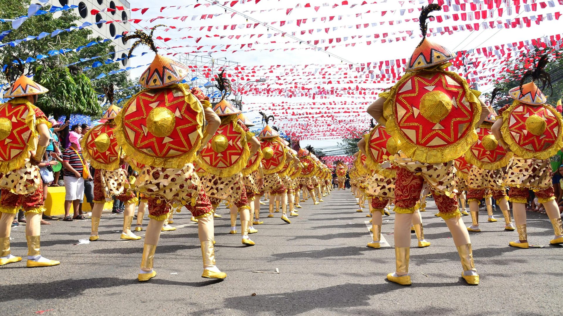 A lively street festival with costumed dancers in a parade, showcasing cultural celebrations.