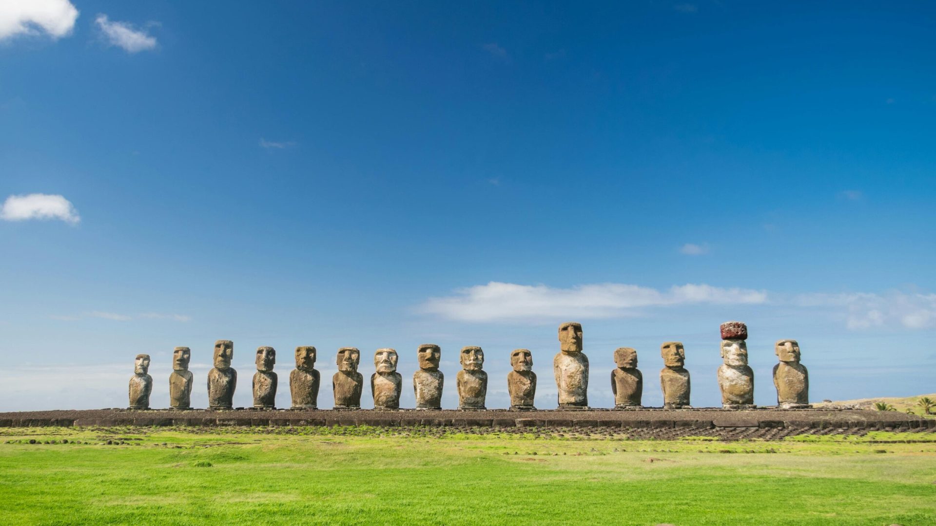 Discover the iconic moai statues on Easter Island against a vibrant blue sky in Chile.