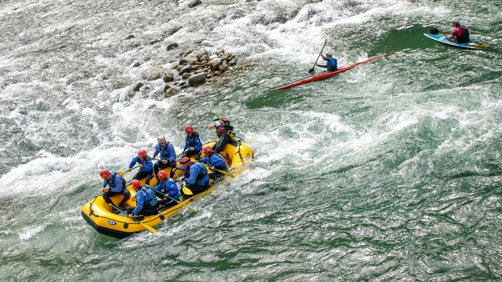 Group enjoying whitewater rafting on a lively river in Valstagna, Italy.