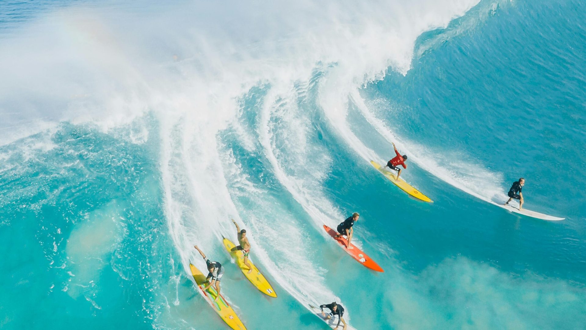 A dynamic shot of surfers riding a big wave at Waimea Bay, Hawaii. Ideal for sports and adventure themes.
